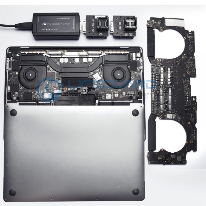 Open laptop with exposed internal components, motherboard removed and placed to the side, alongside various electronic tools